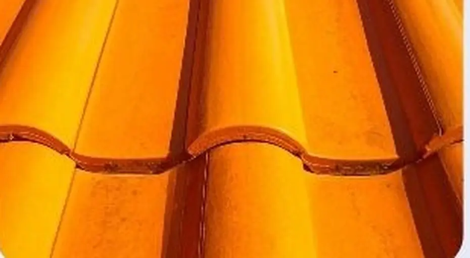 Concrete roof tile close-up showing the pigmented surface coat and profile edge