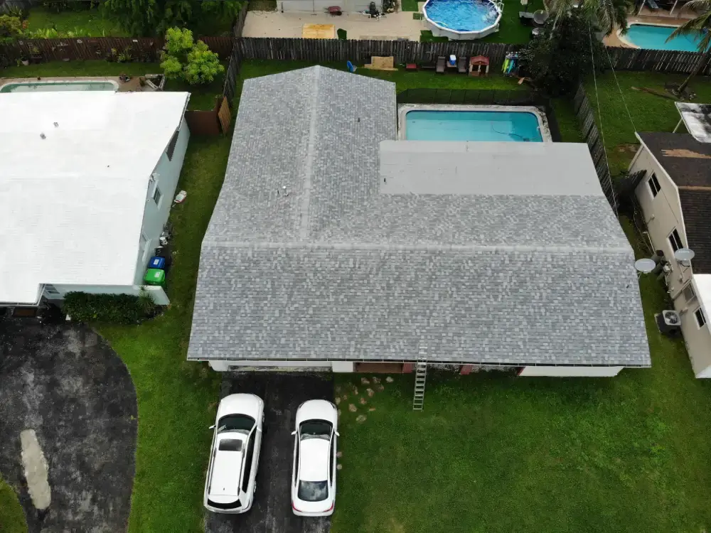 Aerial view of a completed light gray shingle roof on a South Florida single-story home